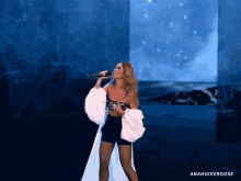 a woman singing into a microphone with anahioverdose written on the bottom right