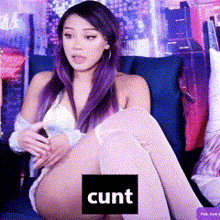 a woman with purple hair is sitting on a couch with the word cunt in a square