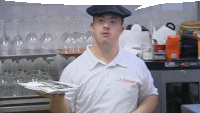 a man with down syndrome is wearing a hat and holding a plate