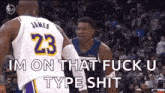 a basketball player with the number 23 on his jersey is talking to another player during a game .
