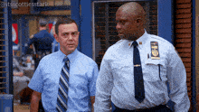 two police officers are standing next to each other and one of them has a badge on his chest that says nypd