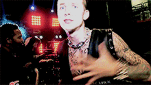 a man with a tattoo on his arm is wearing a black vest that says ' 19xx ' on it