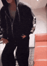 a person wearing a black hoodie with chinese writing on the arm