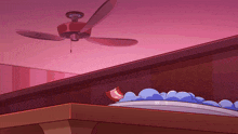 a ceiling fan hangs over a table with a plate of food on it