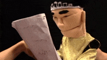 a puppet is holding a piece of paper that says wit on it