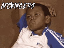 a young boy is sitting on a couch with the words afchingers written above him