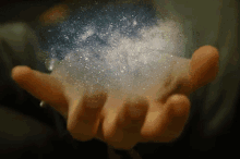 a person is holding something in their hand that looks like a starry sky