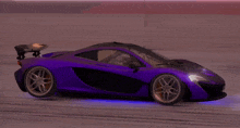 a purple mclaren p1 is driving down a track at night .