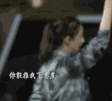 a blurry picture of a woman with chinese writing on the back of her shirt