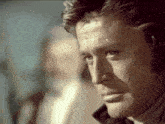 a close up of a man 's face with a blurry background behind him