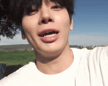 a close up of a person 's face with a blue sky in the background