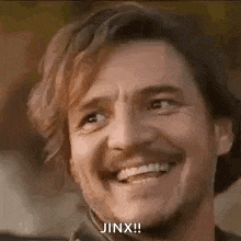 a close up of a man with a beard smiling and saying jinx !