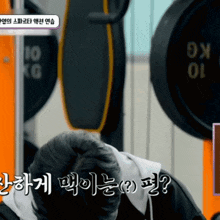 a person in a gym with the number 10 on the barbell