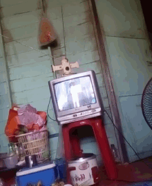 a tv is sitting on a red stool in a room