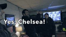 a group of people standing in a room with the words " yes chelsea " on the bottom