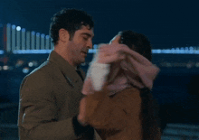 a man and a woman dancing in front of a bridge