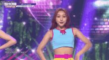 a woman in a blue crop top is dancing on stage .