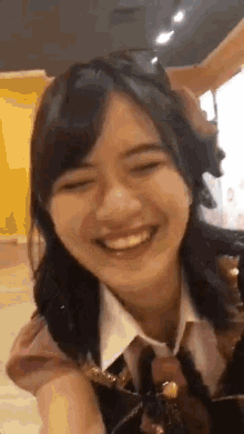 a young woman is smiling with her eyes closed while wearing a white shirt and tie .