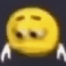 a blurry picture of a yellow smiley face with white hands on a dark background .