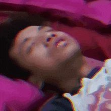a blurry picture of a person laying on a bed with their eyes closed