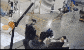 a camera is pointed at a group of people in a warehouse