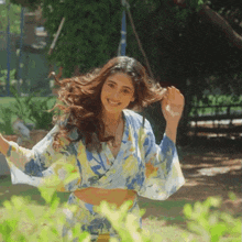 a woman in a floral crop top and skirt is dancing