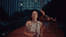 a woman in a floral dress is running in the dark