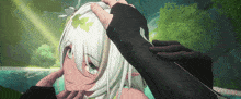 a person is touching a girl 's head with their hands