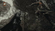 two men are fighting in a forest with a tv logo in the corner