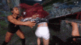 two women are fighting in front of a wall that says ' wwe live ' on the bottom