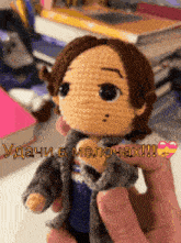 a person is holding a crocheted doll with the words " удачи в мелочах " on the bottom