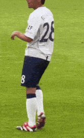 a soccer player wearing a white shirt with the name tomlinson on it
