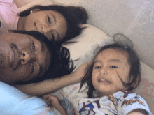 a man and two children laying on a bed