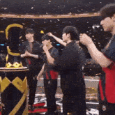 a group of people are standing around a table with a trophy in the background .