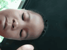 a close up of a child 's face with a black shirt on