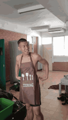 a shirtless man wears an apron that says cooking on it