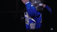 a person wearing a blue jacket with chinese writing on it .