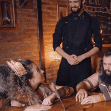 a man and a woman are sitting at a table in front of a sign that says ' menu '