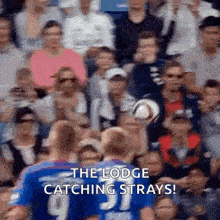 a group of people are watching a soccer game and one of the players is wearing a number 9 jersey .