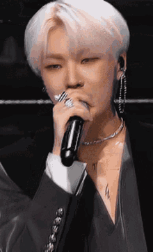 a man in a suit is singing into a microphone
