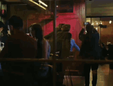 a group of people are gathered in a dark room and one man is taking a picture of a woman