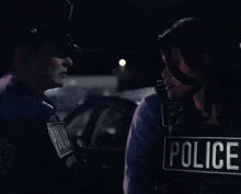 two police officers are standing next to each other and one has a police badge on her chest