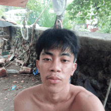 a man without a shirt is taking a selfie