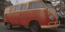 a red and yellow van is parked on the side of a road