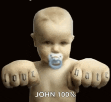 a baby with a pacifier in his mouth is holding his fists up in the air .