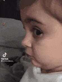 a baby is making a funny face while looking at something .
