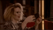a woman is taking a picture of herself with a cell phone .