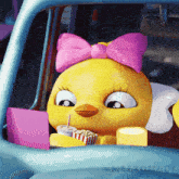 a cartoon chicken with a pink bow is sitting in a car