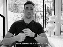 a black and white photo of a man with the website www.wholesalewithnate.com on the bottom right