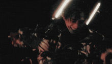 a man in a black jacket is surrounded by lights and feathers